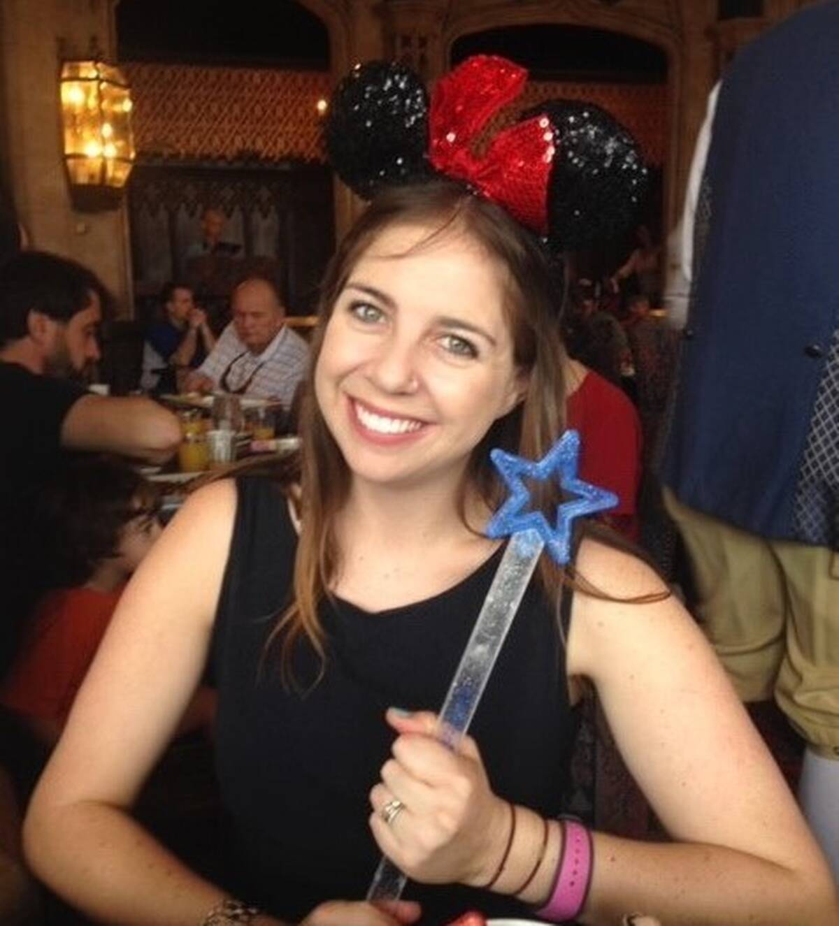Smiling woman with Mickey ears and a wand