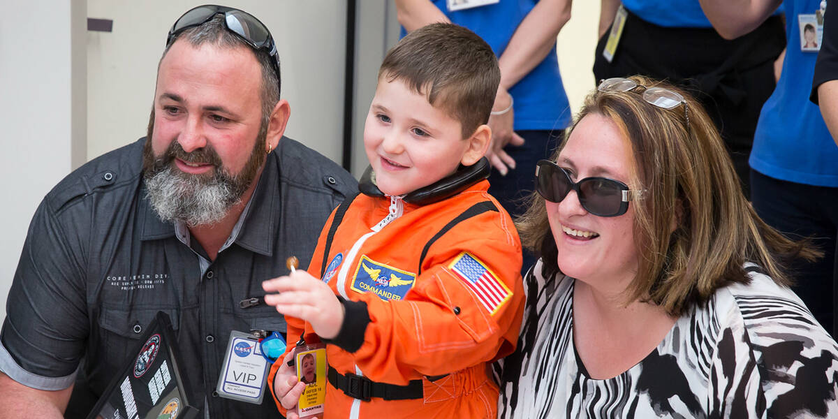 Make A Wish Australia Children's Charity - Dwayne on his wish to go to the moon standing with is parents