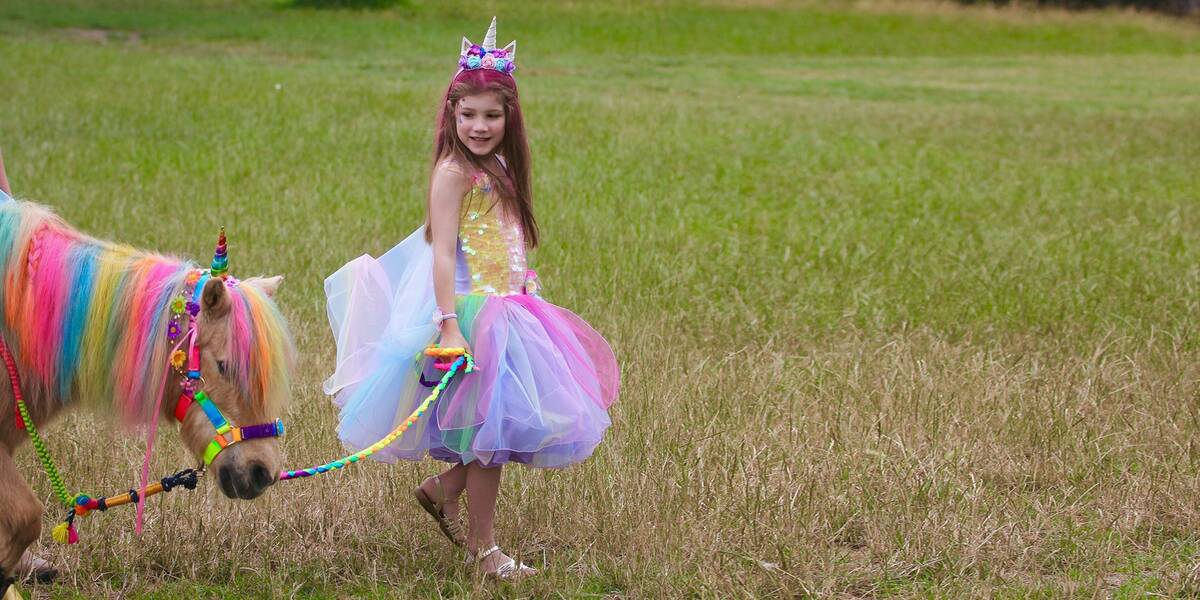 Make A Wish Australia Children's Charity - Abigial on her wish holding the unicorn's reins
