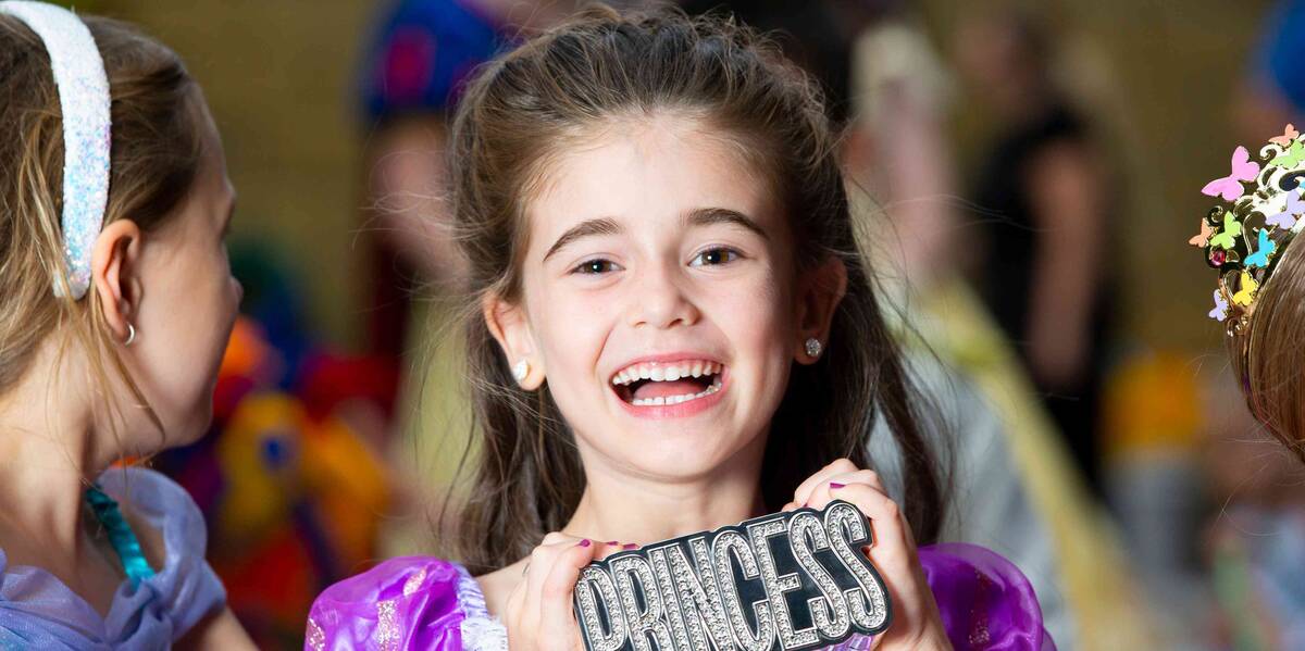 Make-A-Wish Australia wish kid Savannah holding a princess sign