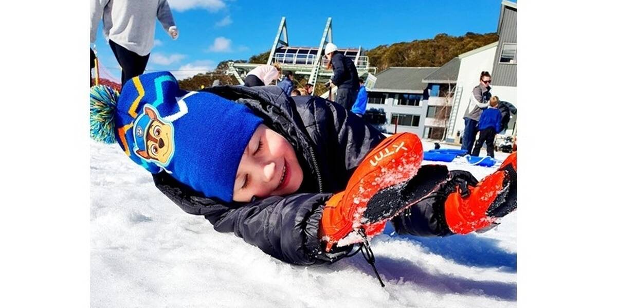Make-A-Wish Australia wish kid Hunter playing in the snow at Mount Hotham