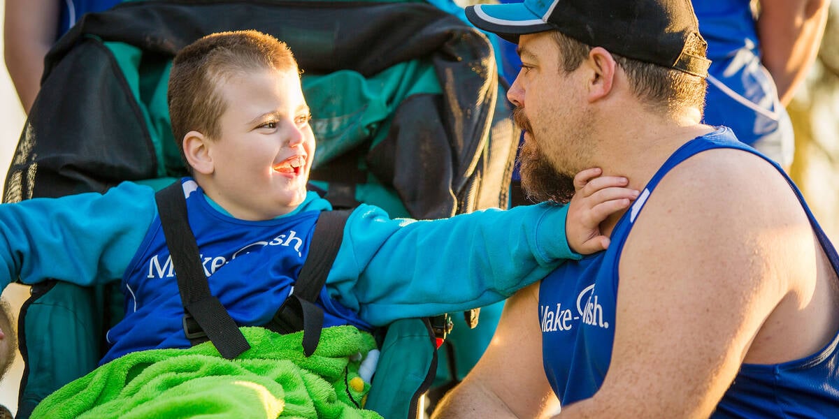 Make A Wish Australia Children's Charity - Aedan on his wish smiling towards his dad
