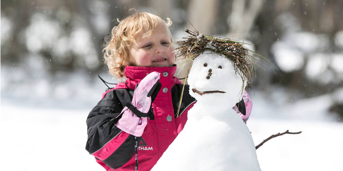 Make A Wish Australia Children's Charity - Isla on her wish in the snow with a snowman