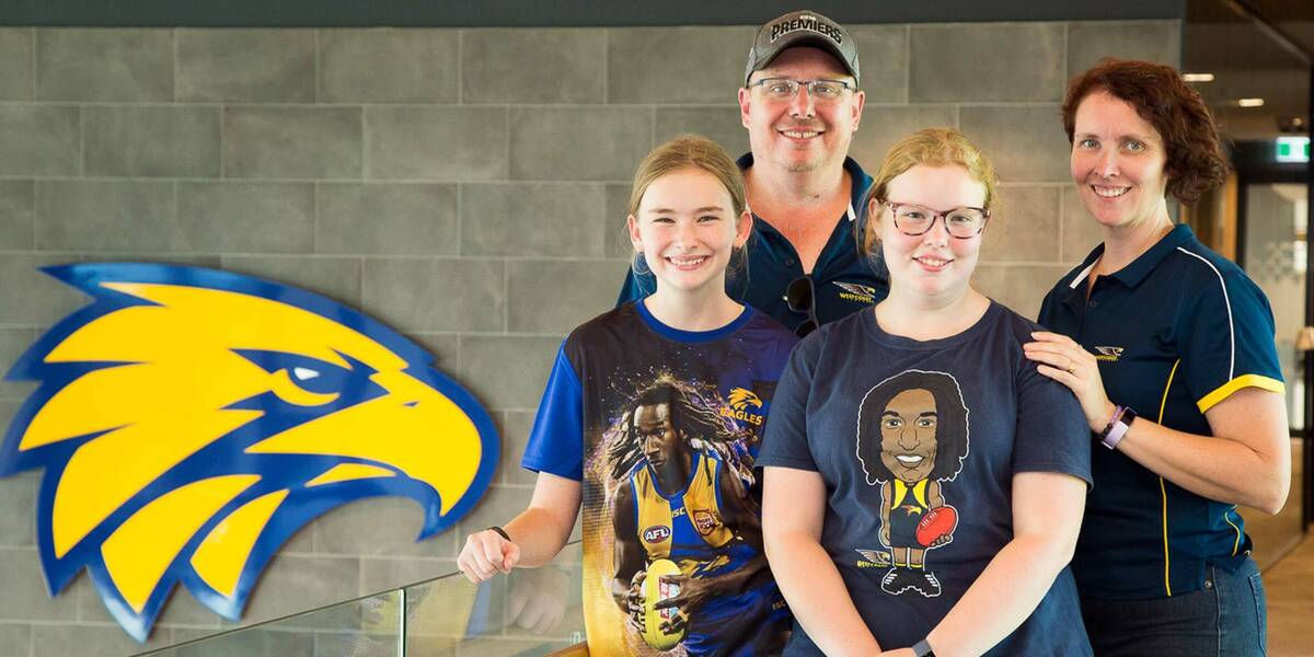 Make-A-Wish Australia wish kid Jacinta standing with family in front of West Coast Eagles sign