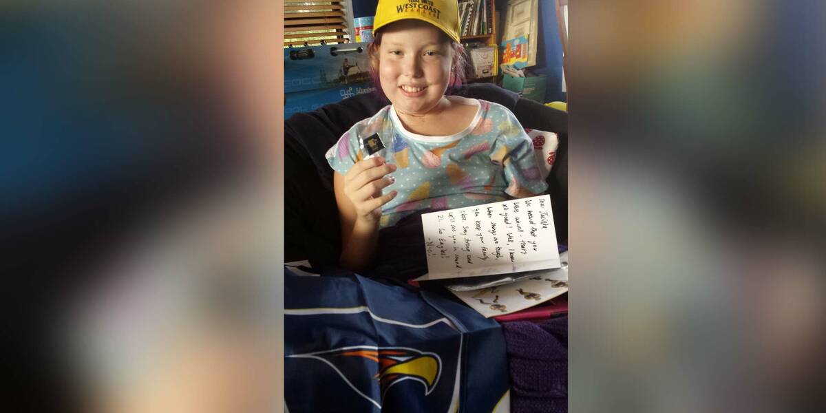 Make-A-Wish Australia wish kid Jacinta holding the letter sent to her by Nic Naitanui