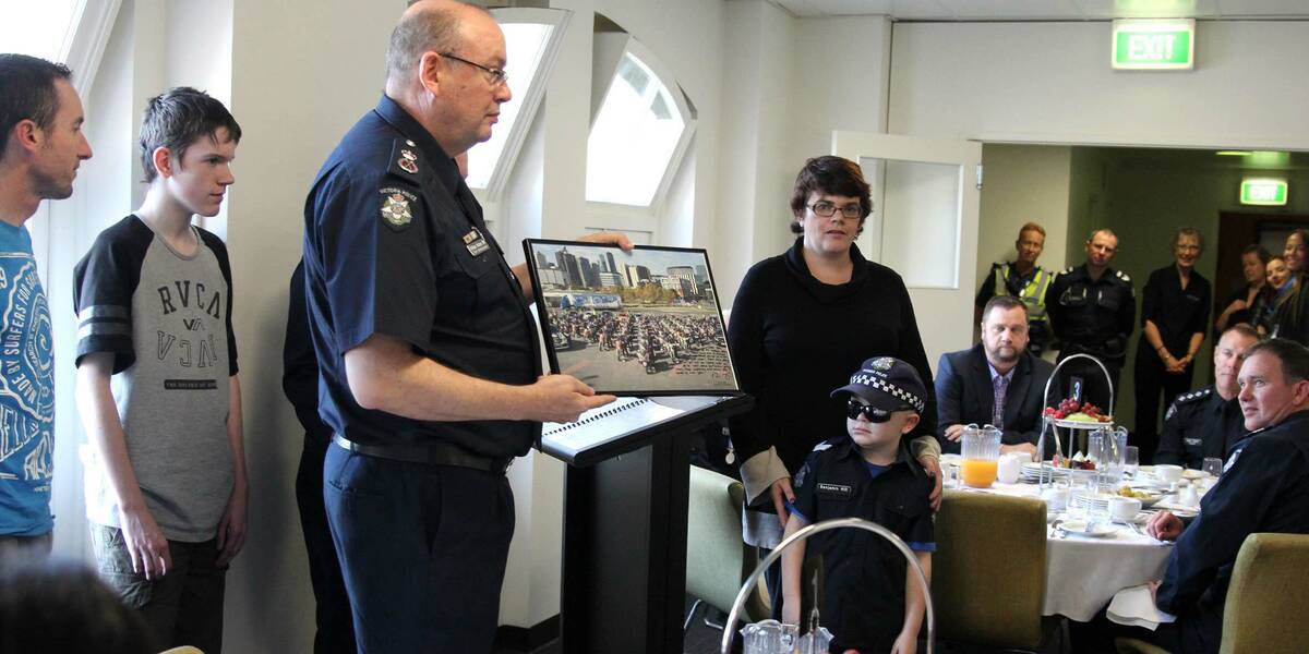 Make-A-Wish Australia wish kid Benjamin being presented with a picture by the police