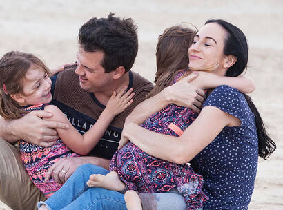 Make A Wish Australia Children's Charity - Audrey with her family hugging on the beach