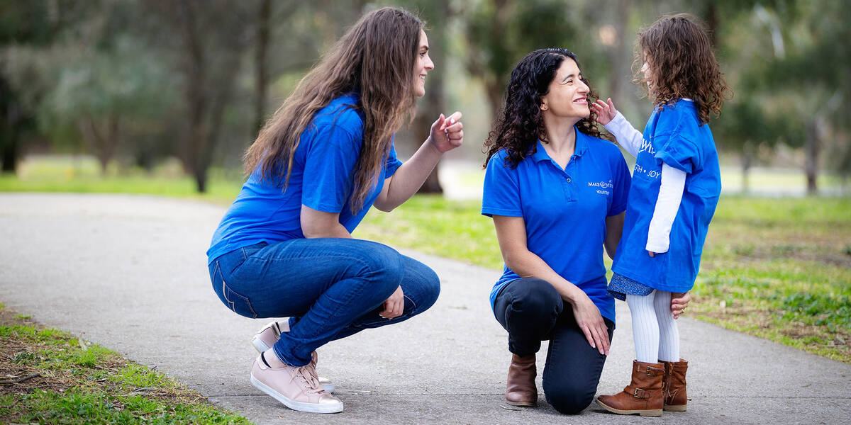 Make A Wish Australia Children's Charity - Female volunteers kneeling down with a wish kid