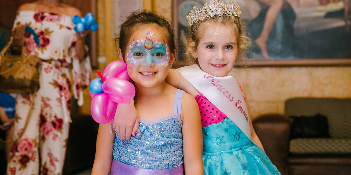 Make A Wish Australia Children's Charity - Emma on her wish to be a rockstar princess wearing her princess crown, sash and posing with a friend smiling