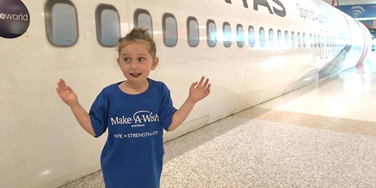 Janey standing in front of a Qantas plane