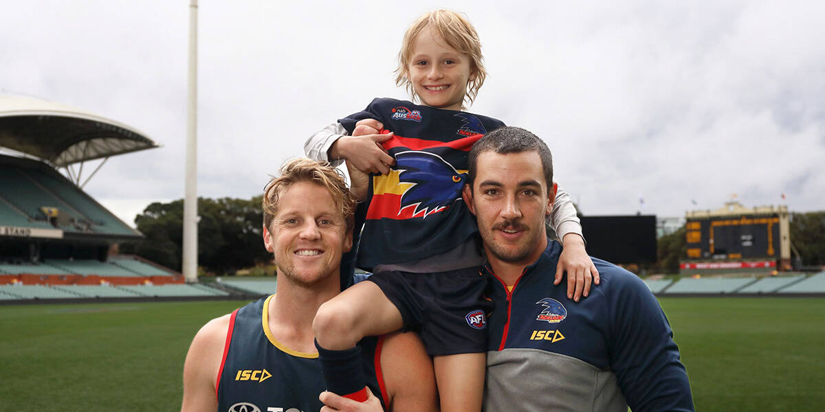 Make-A-Wish Australia wish kid Sullivan on the shoulders of Adelaide Crows players