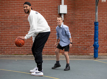 Make-A-Wish Australia wish kid playing basketball in the school yard with NBA star Ben Simmons