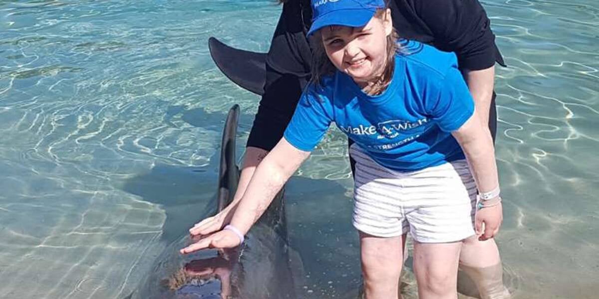 Make-A-Wish Australia wish child Cara at Tangalooma Island Resort in Queensland with a dolphin