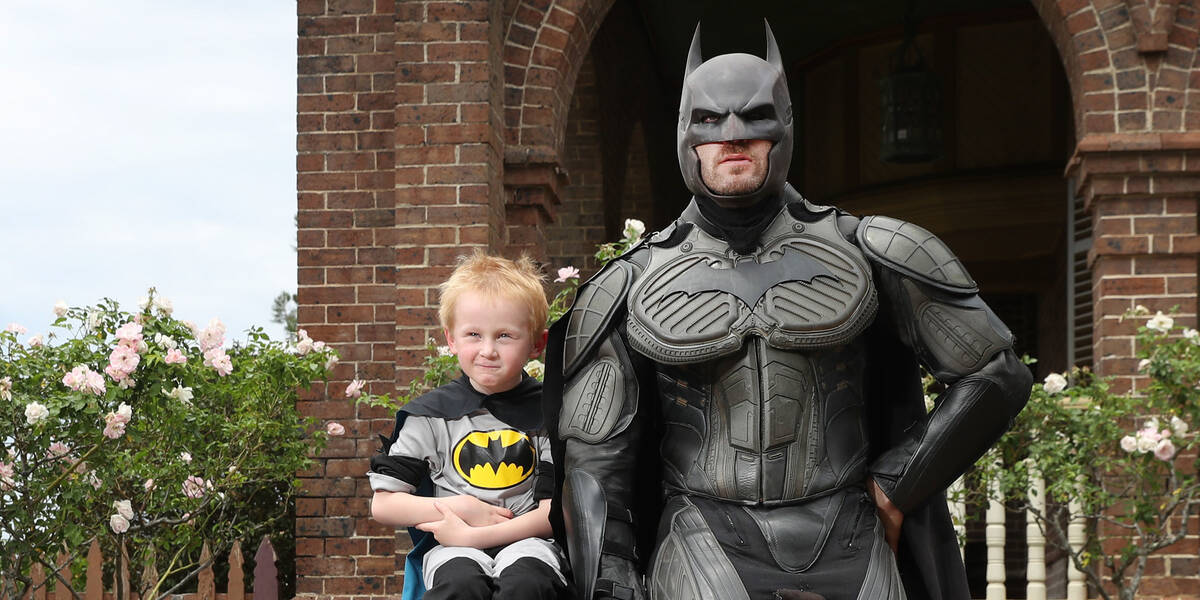 Make-A-Wish kid Rory sits next to batman on wish day