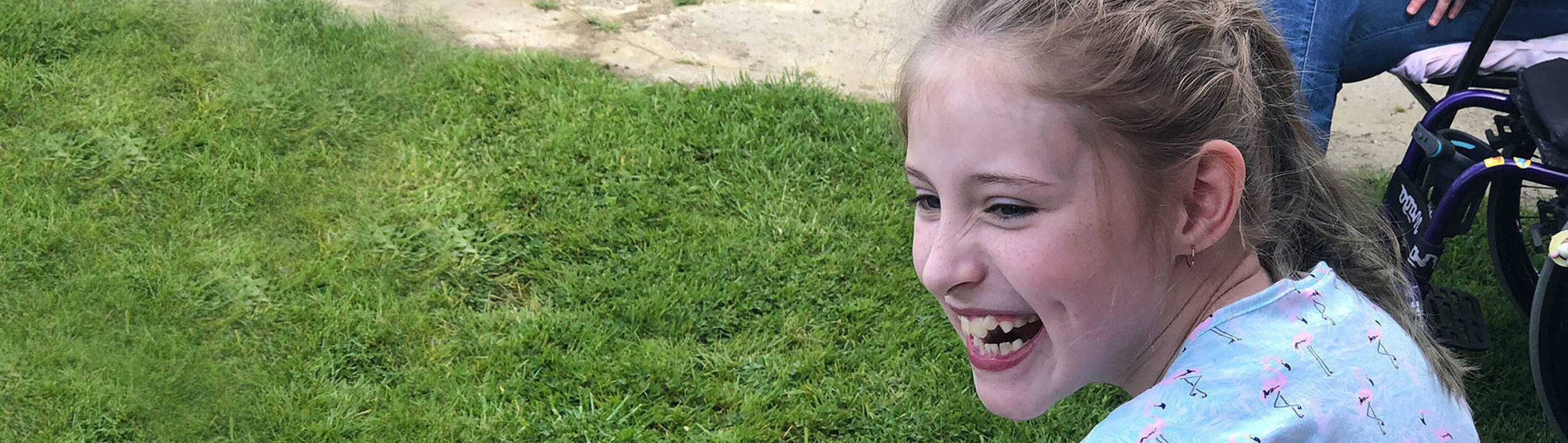 Make-A-Wish Australia wish kid Grace sat smiling in the garden