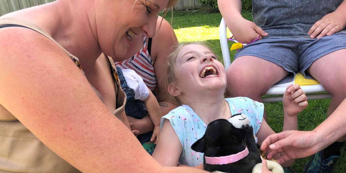 Make-A-Wish Australia wish kid meeting her new black pug puppy for the first time