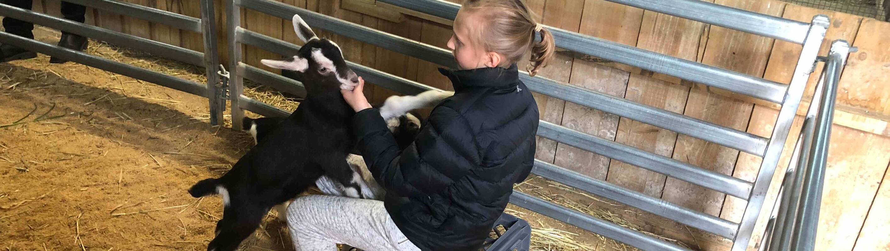 Make-A-Wish Australia wish kid Ava at a farm with a baby goat