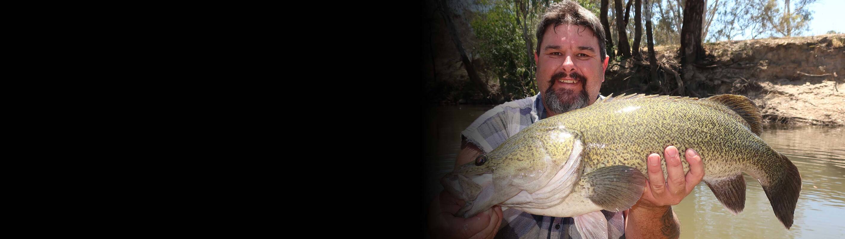 Make-A-Wish Australia volunteer Robbie holding up a fish