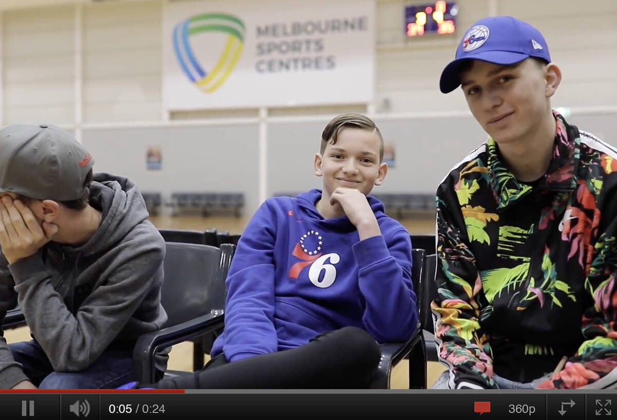Make-A-Wish Australia wish kid Claude sat at the basketball court with friends